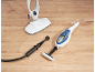 Steam mop and handheld steam cleaner with attachments on a wooden floor.