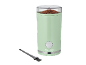Mint green coffee grinder with ground coffee and a cleaning brush.
