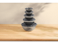 Stacked clear bowls with gray lids on a wooden table.