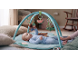 Baby playing on an activity mat with hanging toys, including a bear and a crocodile.