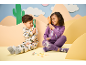 Two children in pajamas with animal prints, holding magnifying glasses and looking at toy insects.
