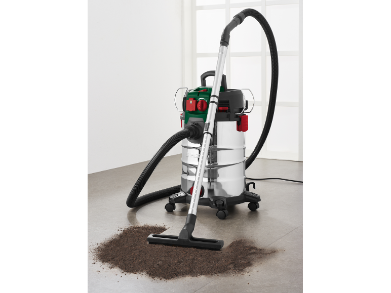 Wet and dry vacuum cleaner with floor nozzle and dirt on the floor.