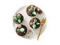 Chocolate muffins with sugar leaf and berry decorations, with a golden fork.