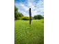 Rotary clothesline with black protective cover in a green garden.