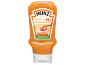 Orange bottle of vegan creamy sriracha sauce with a white label.