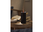 Black aroma diffuser with red light and steam, books and jewelry on a wooden table.