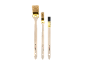 Set of three paint brushes of different sizes with wooden handles and golden ferrules.