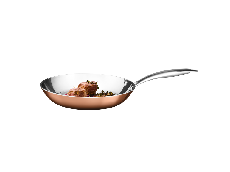 Copper pan with beef fillet and herbs.