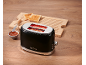 Black toaster with toast, jam, and a wooden board on a table.