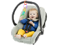 Happy baby in car seat with colorful toys.