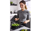 Woman cooking broccoli in a pan on an induction hob.