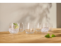 Several stemless glasses, some with sparkling water, lime, and mint, on a wooden surface.