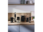 Black kitchen appliances: hand blender, chopper, kettle, milk frother, spice grinder on a wooden counter.