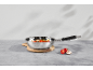 Stainless steel pan with vegetables on a wooden cutting board