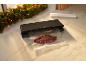 Vacuum sealer with packaged meat and a rosemary sprig on a kitchen counter.