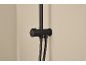 Black shower mixer with two hoses and a control knob on a beige wall.