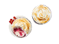 Two meringue desserts with red currants, one with a spoonful taken out.