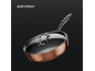 Copper-colored frying pan with a glass lid and a metallic handle on a dark background.