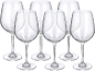 Six clear wine glasses with long stems and wide bowls on a black background.