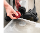 Draining dirty water from a wet and dry vacuum cleaner into a metal tray.