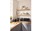 Kitchen with black toaster, kettle, air fryer, and microwave on a wooden countertop.