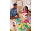 Father and daughter making paper crafts with colorful papers and scissors.