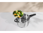 Stainless steel pressure cooker with a steamer basket filled with assorted vegetables.