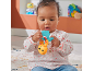 Baby sitting on a rug, playing with a yellow and blue rattle.