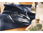 Manicure kit on a blue towel with nail care bottles.