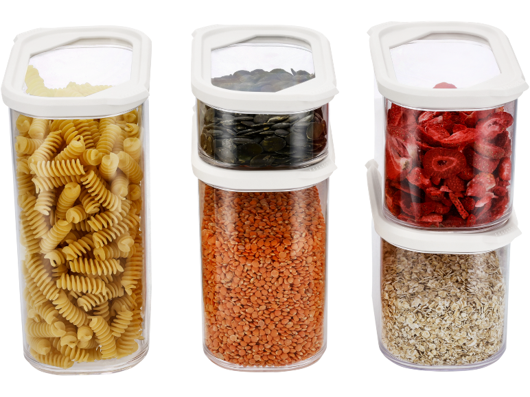 Storage containers with pasta, lentils, pumpkin seeds, dried strawberries, and oats.