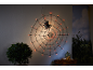 Illuminated spider web with a large spider, pumpkins, and autumn decor for Halloween.