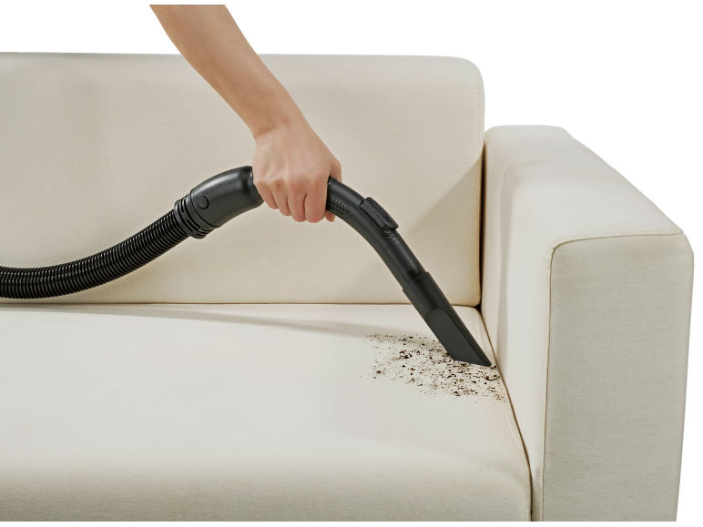 Handheld vacuum cleaner cleaning dirt from a cream sofa.