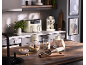 Kitchen with cream air fryer, espresso machine, and food processor, preparing breakfast.