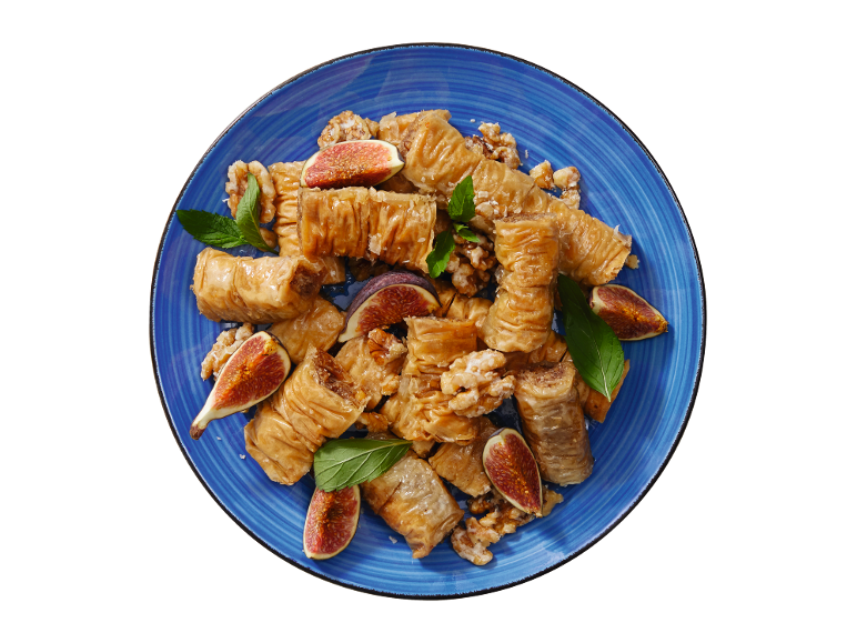 Baklava with figs, walnuts, and mint on a blue plate.
