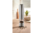 Stainless steel electric pepper mill with peppercorns on a wooden kitchen counter.