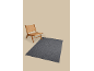 Wooden chair with woven seat and backrest on a gray rug.