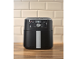 Black air fryer with digital control panel on a wooden countertop and beige tiles.