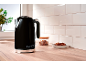 Black kettle with '1973' on a wooden countertop with cookies.