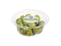 Green olives with pits in a clear plastic container.