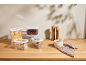 Transparent storage containers with pasta, beans, muesli, and lentils on a wooden countertop.