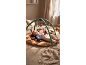 Baby playing on a playmat with an activity arch and hanging toys.