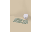 Two green striped bath mats in a bathroom with a wall-mounted toilet.