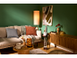 Living room with green walls, beige sofa, autumn decor, and a decorative gnome.