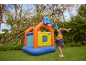 Girl playing with a colorful inflatable bouncy castle with a basketball hoop and rings in the garden.