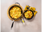 Pasta with shrimp and tomatoes in a pan and bowl, with lemon water.