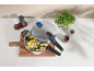 Open pressure cooker with rice and vegetables on a wooden cutting board, with spices.