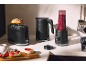 Black toaster, kettle, and blender on a kitchen counter, breakfast setup.