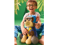 Smiling boy with glasses and a plush dog on a green background.