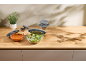 Kitchen counter with food storage bowls filled with salad, soup, and olives.