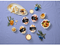 Assorted mini ice cream desserts (Mocha & Hazelnut, Peach & Vanilla, Banana & Caramel, Macadamia & Vanilla) on a purple background, festively decorated.